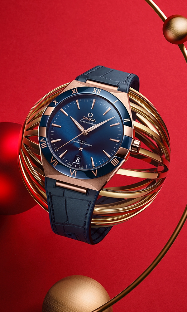 直徑41毫米的18K Sedna™金腕錶，光面藍色陶瓷錶圈鐫刻Ceragold™羅馬數字刻度，襯上太陽線紋打磨藍色表面，6時位置設有日曆窗。指針、Omega標誌、星座星徽和三角拱形小時刻度均以18K Sedna™金鑄造。這款腕錶選配橡膠襯底藍色真皮錶帶，內置Omega Co-Axial Master Chronometer機芯8901，通透的弧拱造形防磨損藍寶石水晶錶背可一覽機芯的形態。