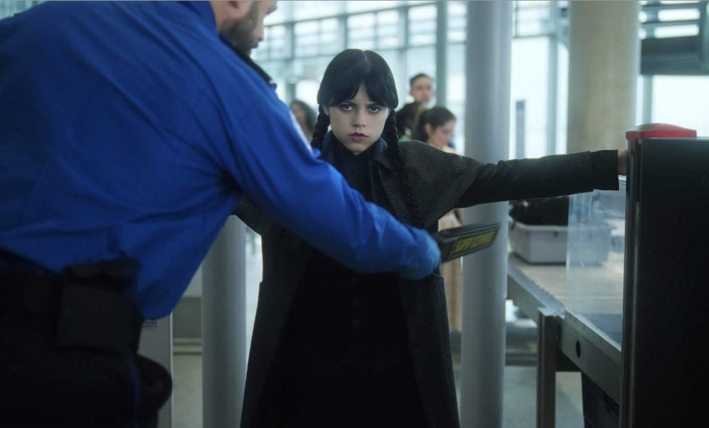 Wednesday 星期三在機場因攜帶多種武器如電擊棒、手指虎和多把大刀,導致過不了安檢。(圖片來源:劇集《Wednesday》截圖)